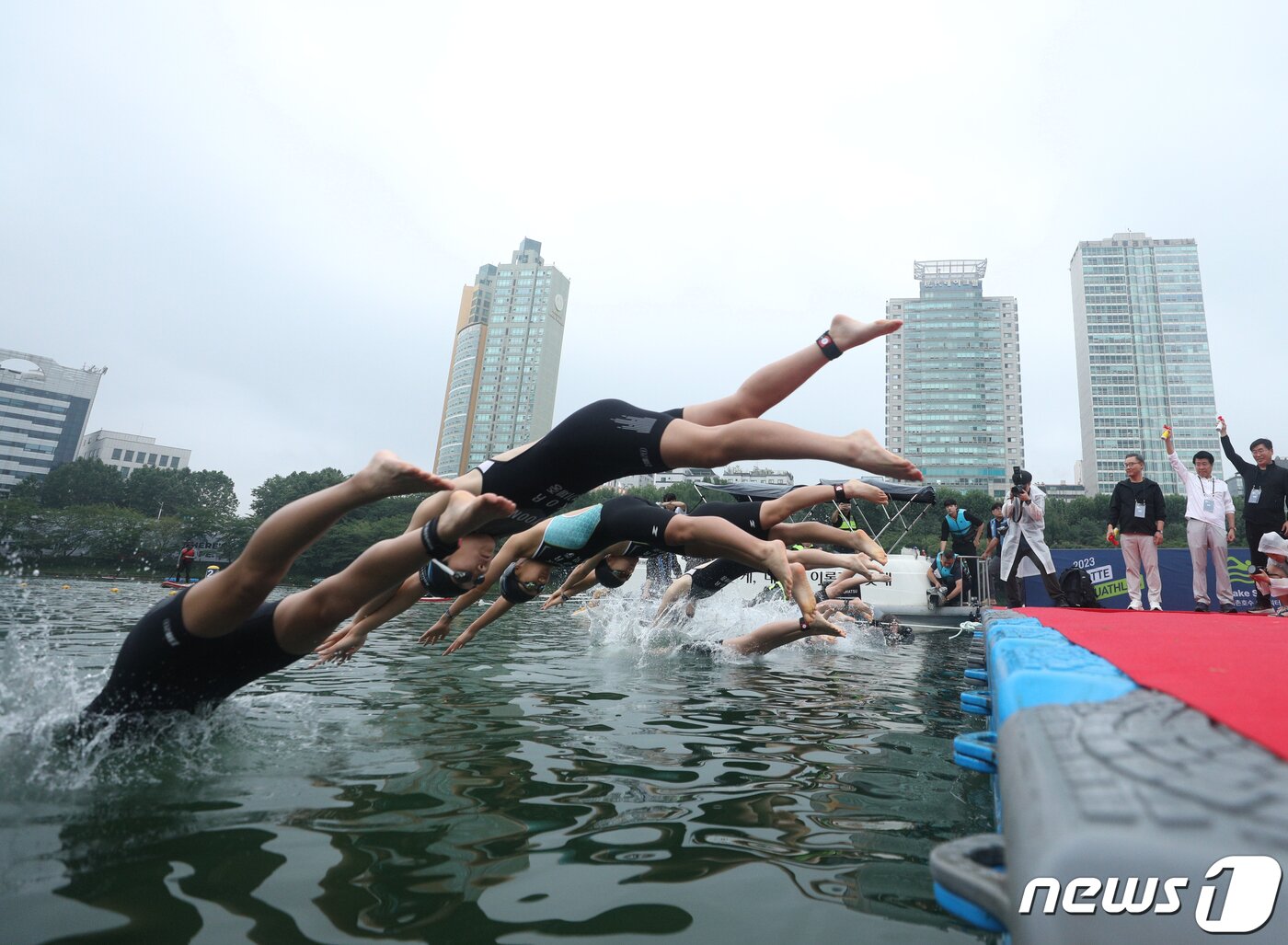 본문 이미지 - 16일 오전 서울 송파구 롯데월드타워 일대에서 열린 '2023 롯데 아쿠아슬론 대회'에 출전한 참가자들이 석촌호수에서 수영을 하고 있다. 2023.7.16/뉴스1 ⓒ News1 신웅수 기자