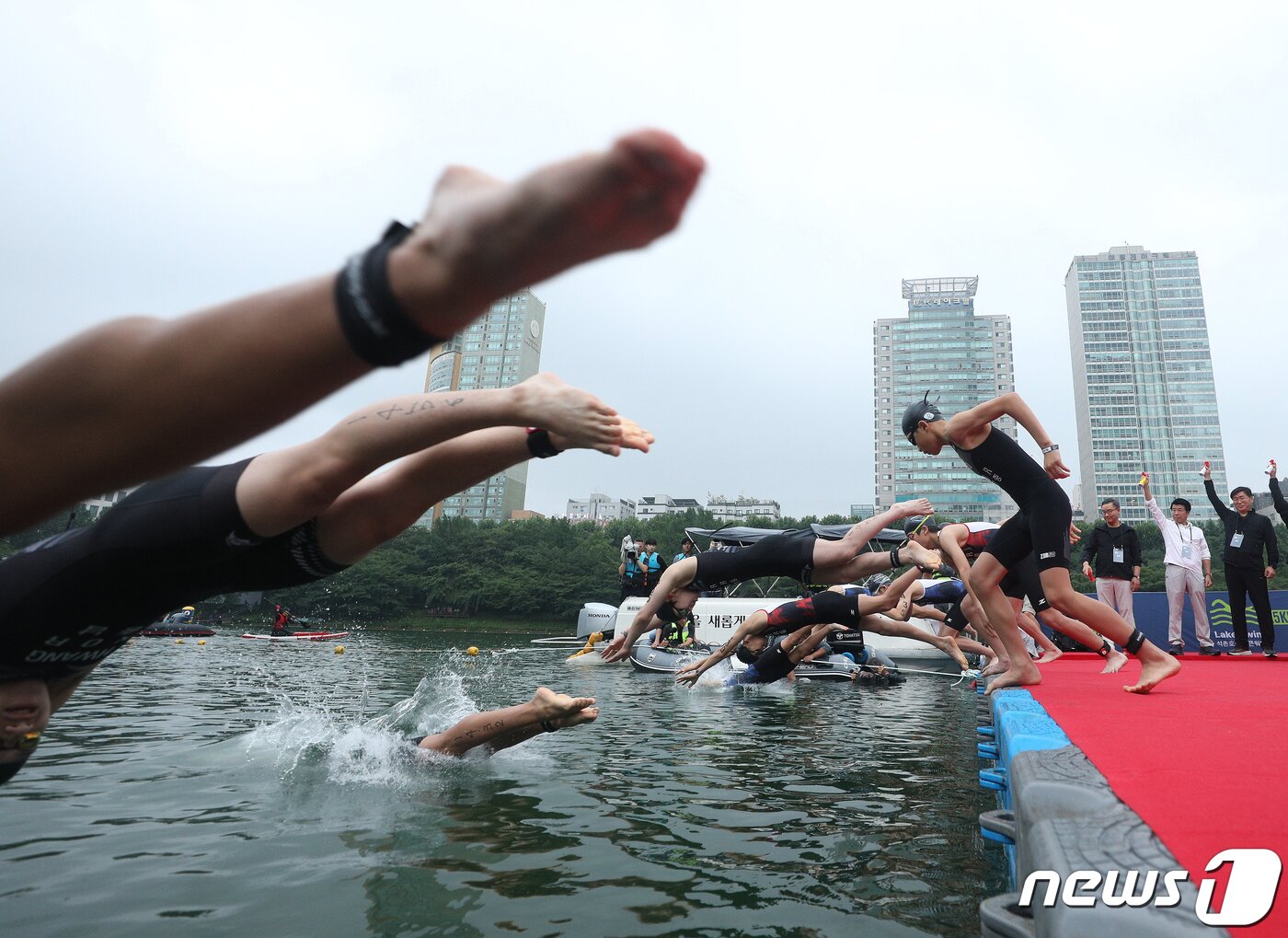 본문 이미지 - 16일 오전 서울 송파구 롯데월드타워 일대에서 열린 '2023 롯데 아쿠아슬론 대회'에 출전한 참가자들이 석촌호수에서 수영을 하고 있다. 2023.7.16/뉴스1 ⓒ News1 신웅수 기자