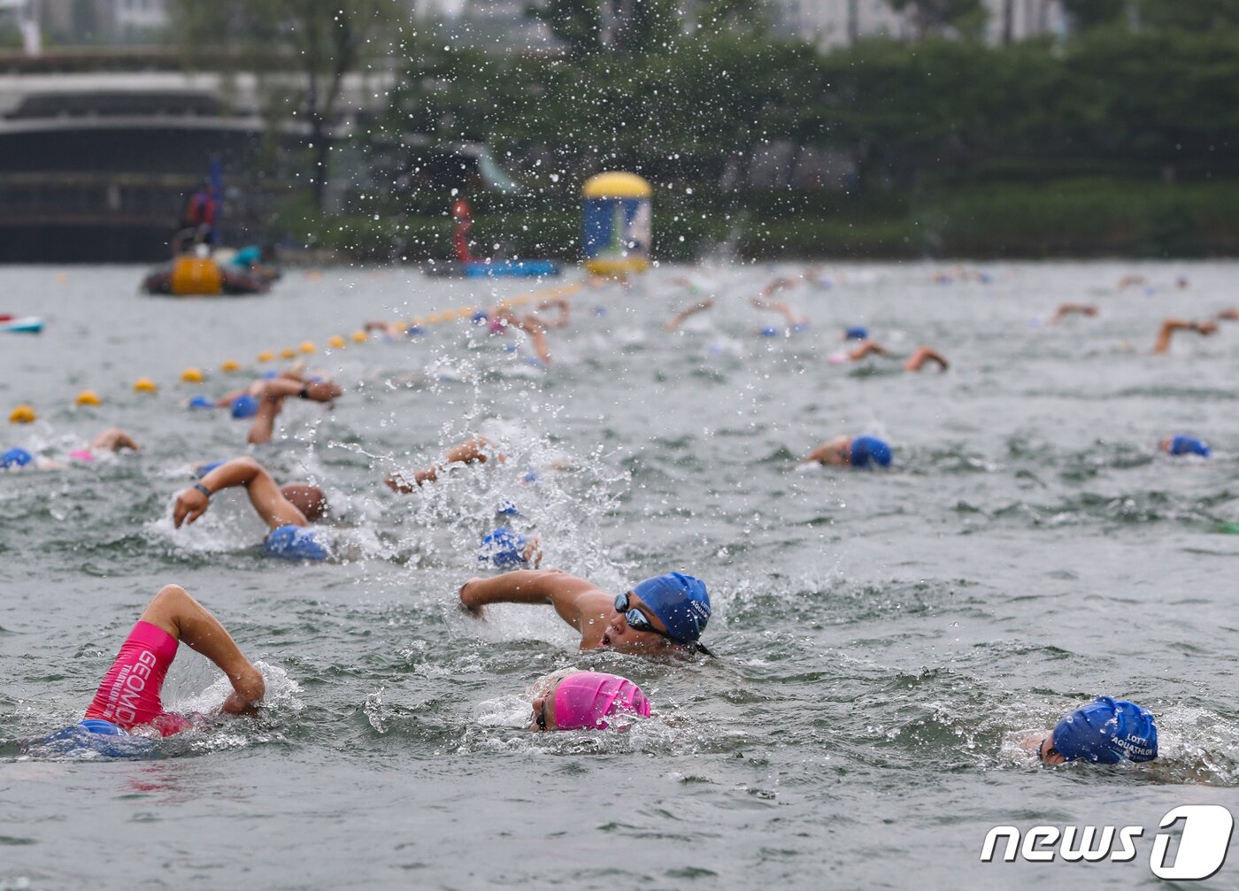 본문 이미지 - 16일 오전 서울 송파구 롯데월드타워 일대에서 열린 '2023 롯데 아쿠아슬론 대회'에 출전한 참가자들이 석촌호수에서 수영을 하고 있다. 2023.7.16/뉴스1 ⓒ News1 신웅수 기자