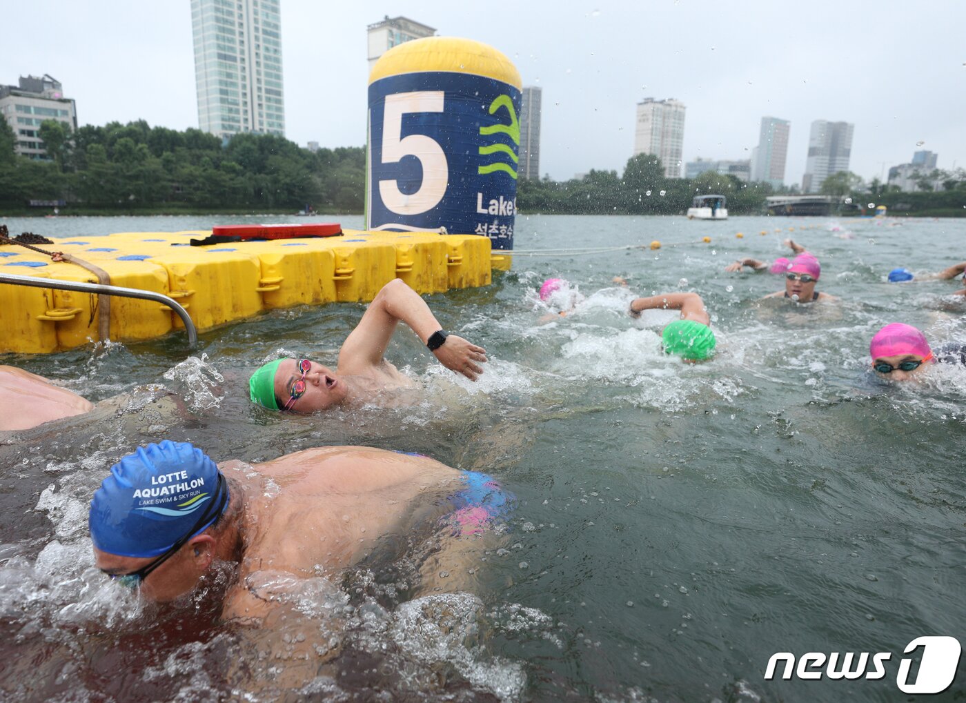 본문 이미지 - 16일 오전 서울 송파구 롯데월드타워 일대에서 열린 '2023 롯데 아쿠아슬론 대회'에 출전한 참가자들이 석촌호수에서 수영을 하고 있다. 2023.7.16/뉴스1 ⓒ News1 신웅수 기자