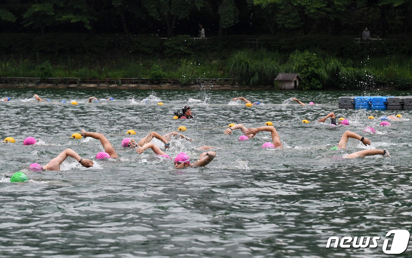 본문 이미지 - 16일 오전 서울 송파구 롯데월드타워 일대에서 열린 '2023 롯데 아쿠아슬론 대회'에 출전한 참가자들이 석촌호수에서 수영을 하고 있다.  (공동취재) 2023.7.16/뉴스1 ⓒ News1 신웅수 기자