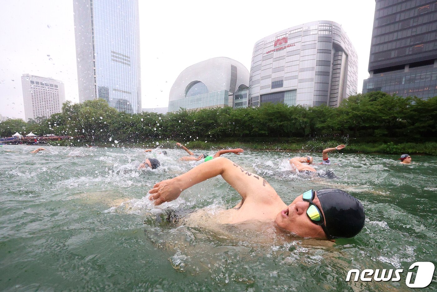본문 이미지 - 16일 오전 서울 송파구 롯데월드타워 일대에서 열린 '2023 롯데 아쿠아슬론 대회'에 출전한 참가자들이 석촌호수에서 수영을 하고 있다. (공동취재) 2023.7.16/뉴스1 ⓒ News1 신웅수 기자