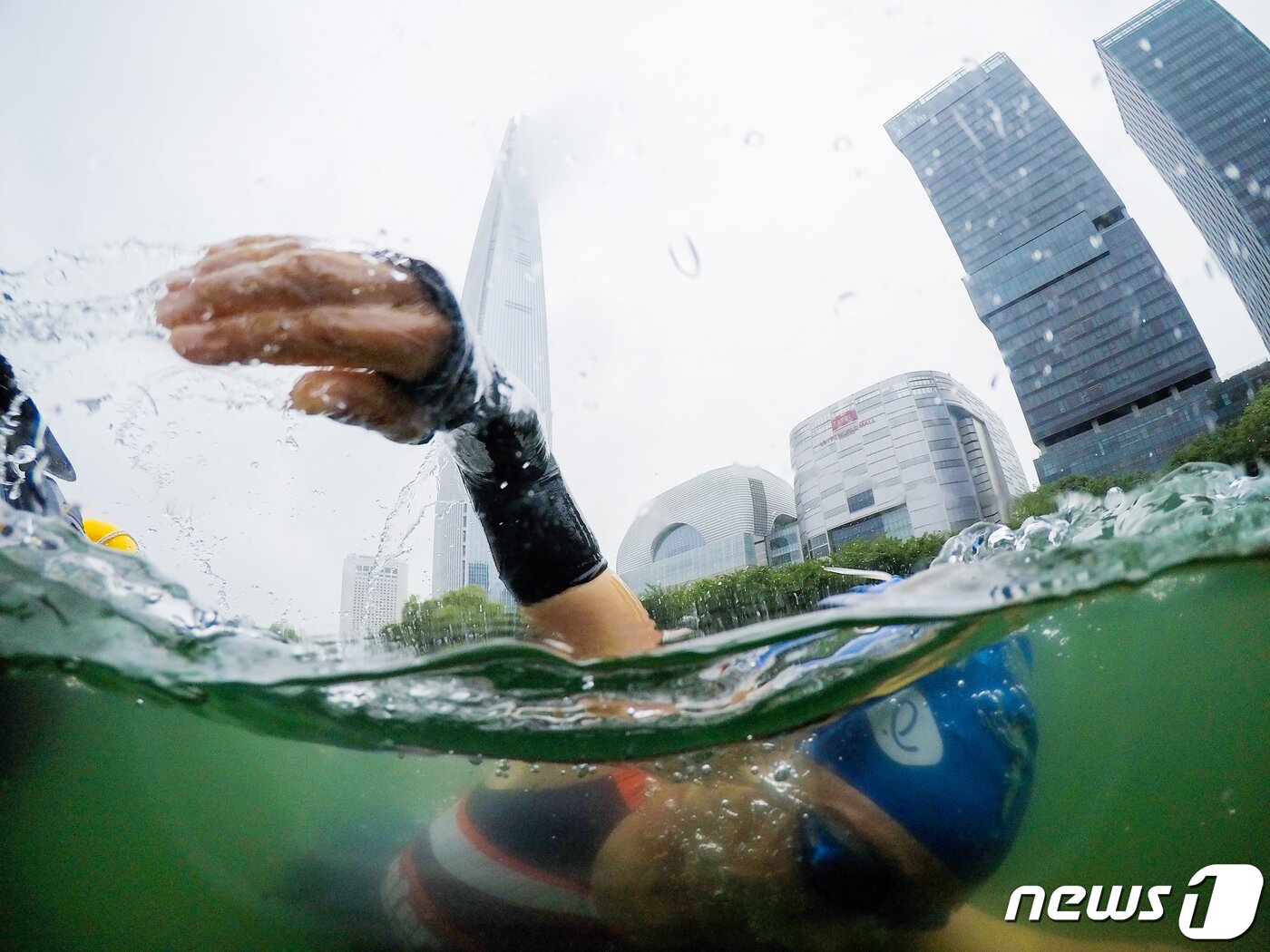 본문 이미지 - 16일 오전 서울 송파구 롯데월드타워 일대에서 열린 '2023 롯데 아쿠아슬론 대회'에 출전한 참가자들이 석촌호수에서 수영을 하고 있다. (공동취재) 2023.7.16/뉴스1 ⓒ News1 신웅수 기자