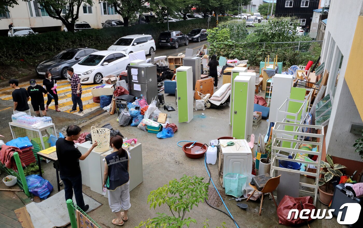 본문 이미지 - 16일 오후 충남 공주시 옥룡동에 위치한 한 요양시설에서 관계자들이 물에 잠긴 가전과 집기류를 건물 밖에서 정리하고 있다.  2023.7.16/뉴스1 ⓒ News1 장수영 기자