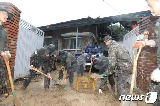 육군 50사단 장병들이 집중 호우로 인해 토사가 밀려든 경북 예천군 감천면 가옥과 도로에 토사를 걷어내고 있다. (육군 제공) 2023.7.16./뉴스1