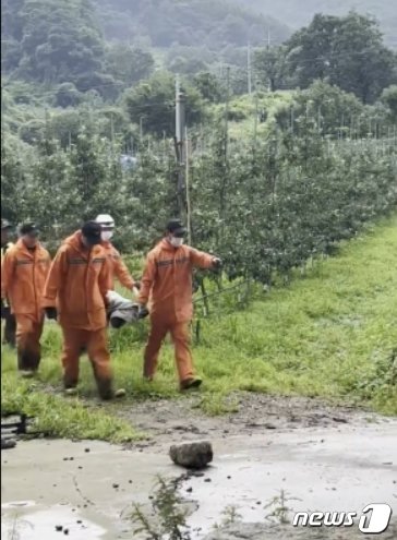 구조당국이 집중호우로 매몰된 예천군 효자면 백석리 한 주택에서 숨진 채 발견된 60대 여성을 옮기고 있다.&#40;경북소방본부 제공&#41;