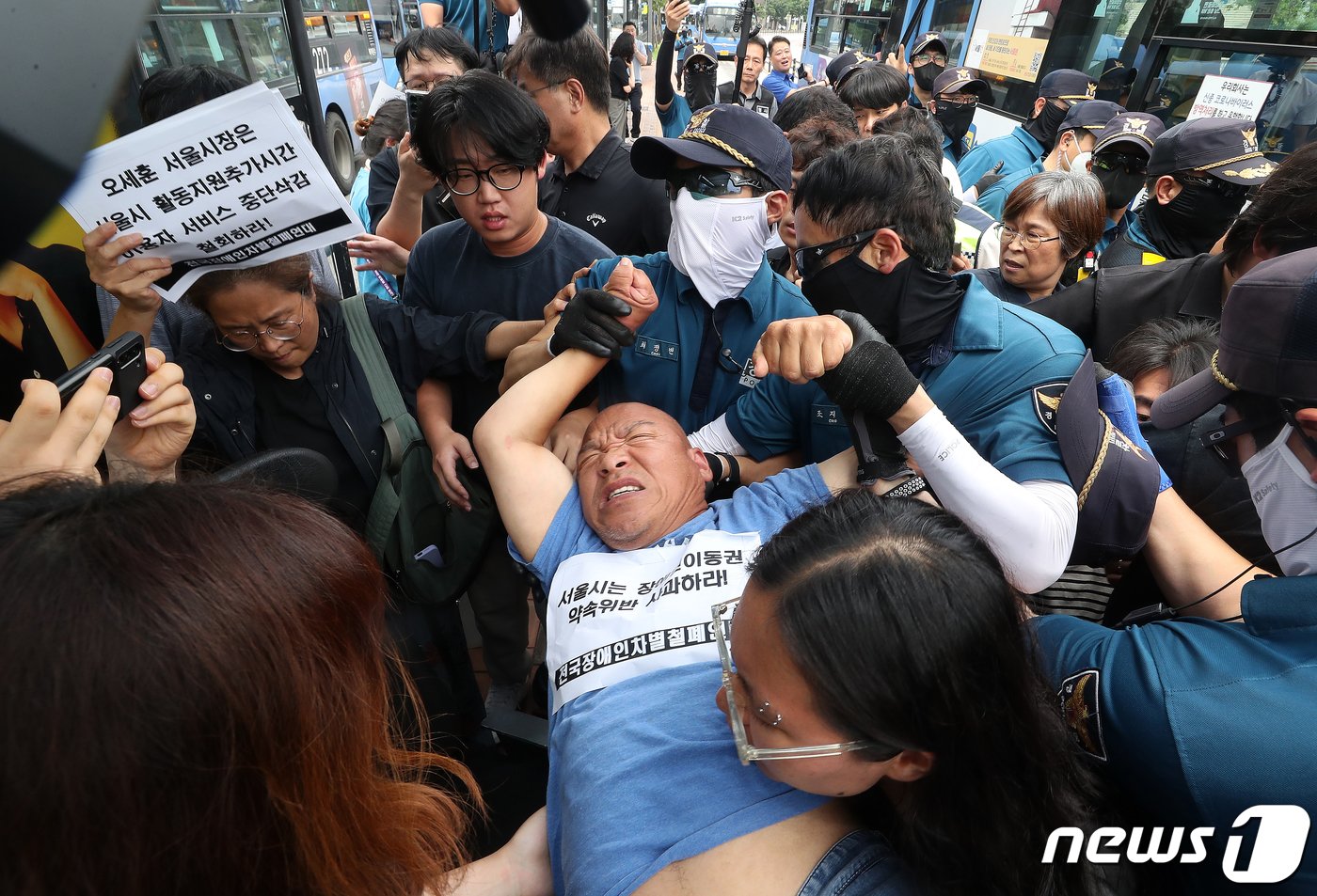 본문 이미지 - 전국장애인차별철폐연대(전장연) 회원들이 17일 오후 서울 종로구 혜화동로터리 버스 정류장에서 전장연 탄압 중단을 촉구하며 '계단 버스' 탑승을 시도했으나 경찰들에 의해 강제 하차되고 있다. 2023.7.17/뉴스1 ⓒ News1 김진환 기자
