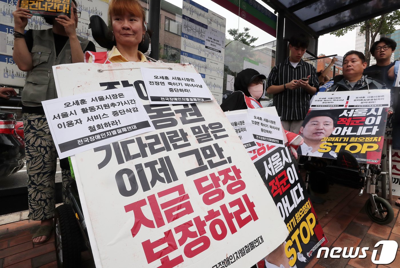 본문 이미지 - 전국장애인차별철폐연대(전장연) 회원들이 17일 오후 서울 종로구 혜화동로터리 버스 정류장에서 전장연 탄압 중단을 촉구하고 있다. 2023.7.17/뉴스1 ⓒ News1 김진환 기자