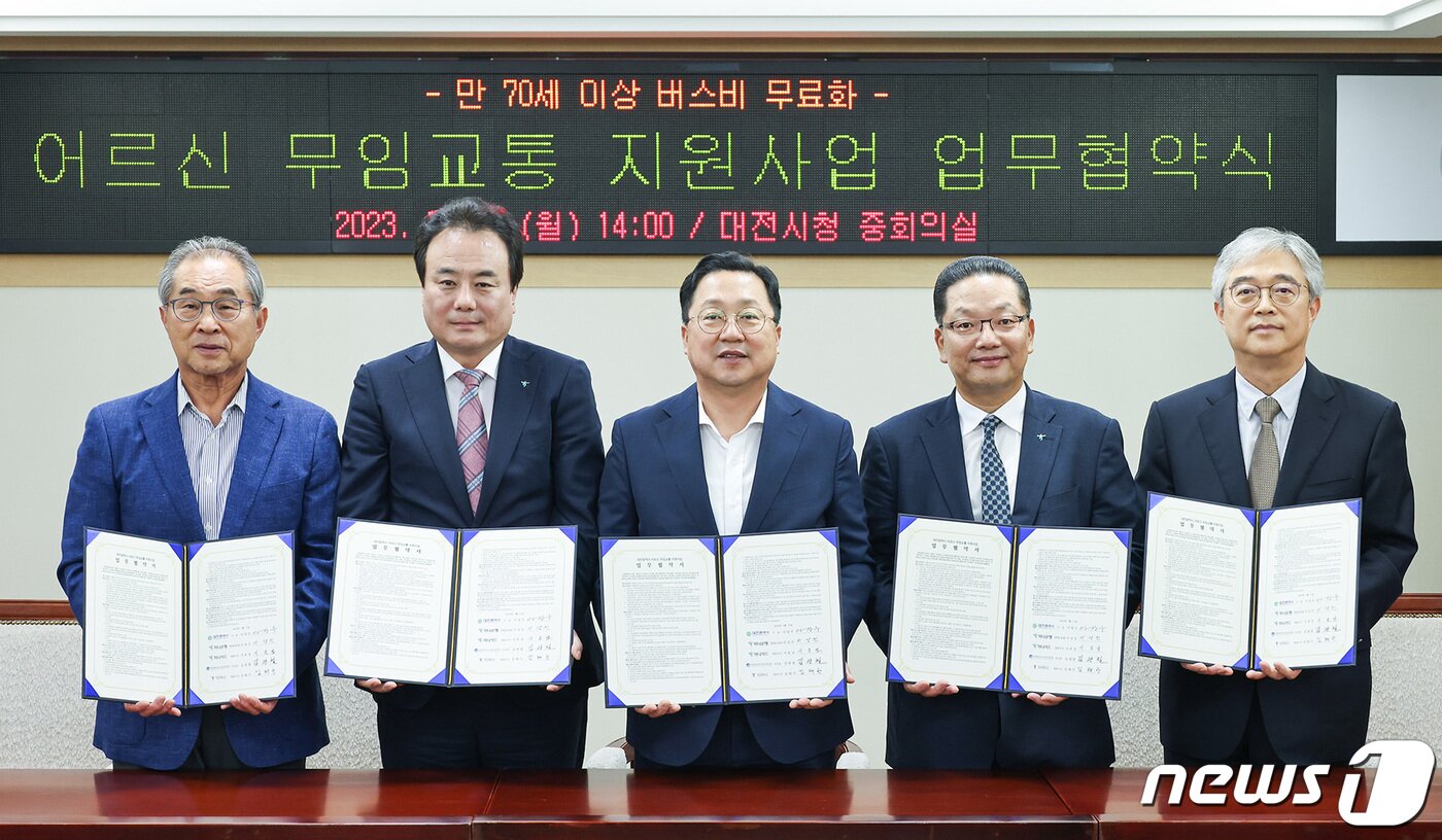 본문 이미지 - 9월 15일 만 70세 이상 버스비 무료화를 시행하는 대전시는 지난달 17일 하나은행·하나카드·대전버스운송사업조합·티머니와 어르신 무임교통 지원사업에 관한 업무협약을 체결했다. 왼쪽부터 김광철 대전버스운송사업조합 이사장, 이성진 하나은행 충청영업그룹 대표, 이장우 시장, 이호성 하나카드 대표이사, 김태극 티머니 대표이사. (대전시 제공) /뉴스1