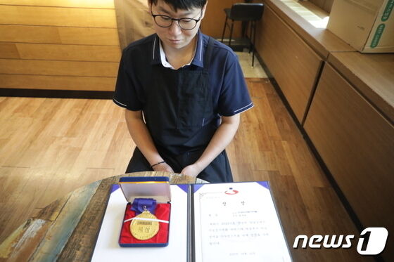 울산 북구청 1층에 위치한 다드림카페에서 바리스타로 근무하고 있는 유재석씨는 지난 6일 '2023 발달장애인 기능경기 영남대회'에서 수상한 동상 상장과 메달을 보여주고 있다.2023.7.17/뉴스1 © News1 김지혜 기자