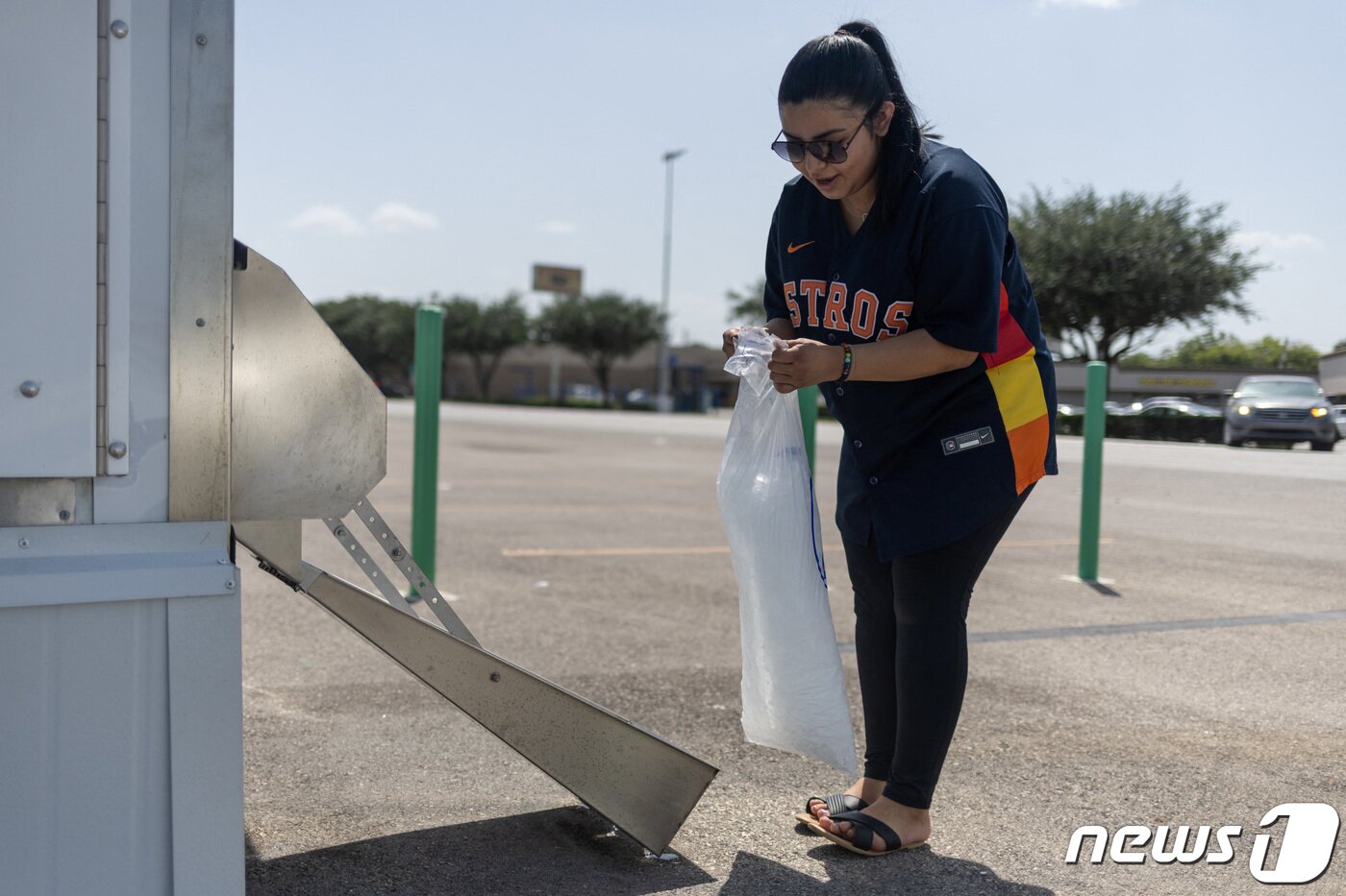 본문 이미지 - 무더운 날씨가 이어지고 있는 미국 텍사스주 휴스턴 지역에서 한 주민이 얼음을 담고있다. 2021.07.17 ⓒ 로이터=뉴스1 ⓒ News1 정지윤 기자