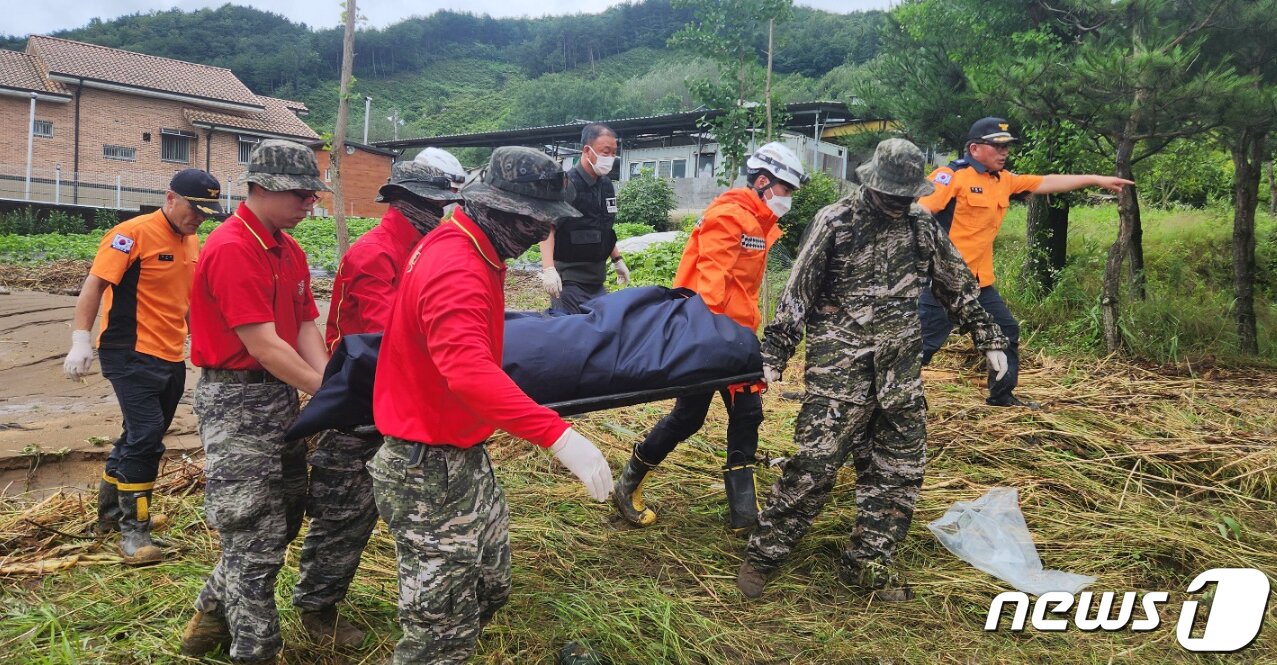 본문 이미지 - 지난 2023년 7월 18일 오전 집중호우 피해 지역인 경북 예천군 용문면 제곡리 한천에서 수색작업을 전개 중이던 해병대신속기동부대 병력에 의해 발견된 실종자 시신이 병원으로 이송되고 있다. 2023.7.18/뉴스1 ⓒ News1 최창호 기자&#40;경북소방본부제공&#41;