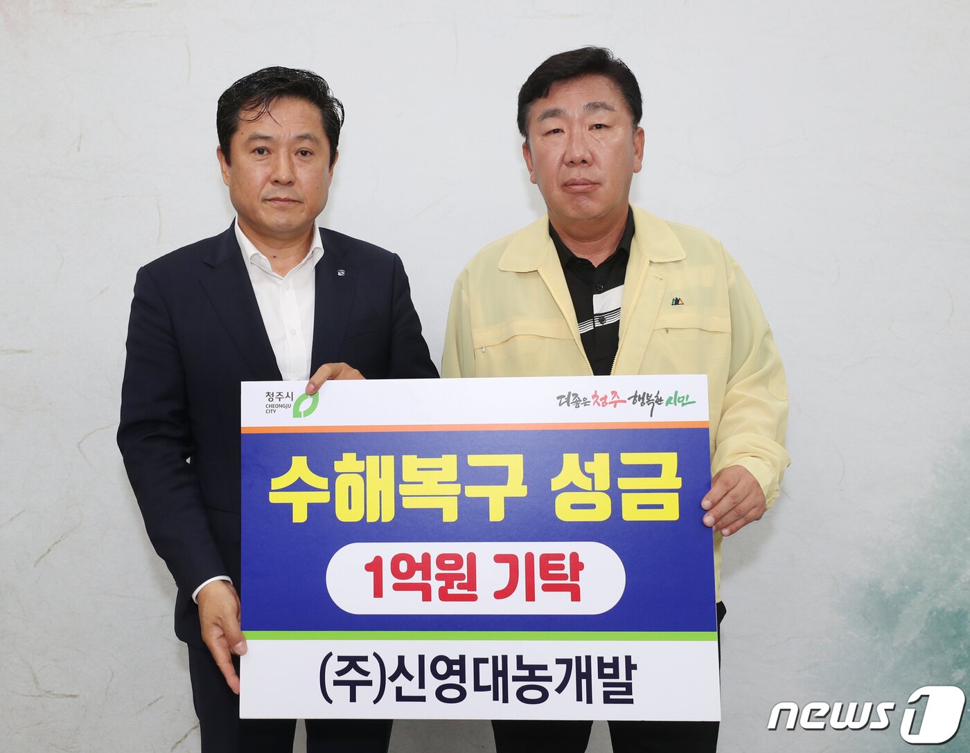 본문 이미지 - 정동희 ㈜신영대농개발 대표(왼쪽)가 19일 청주시청 임시청사에서 이범석 청주시장에게 수해복구 성금 1억원을 전달하고 있다.(청주시 제공).2023.7.19/뉴스1