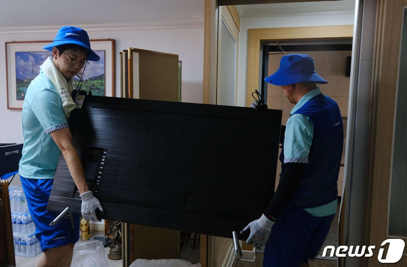 본문 이미지 -  삼성전자서비스 직원이 수해피해 가정의 TV를 옮기고 있다. 2023.7.19/뉴스1 ⓒ News1 강태우 기자 