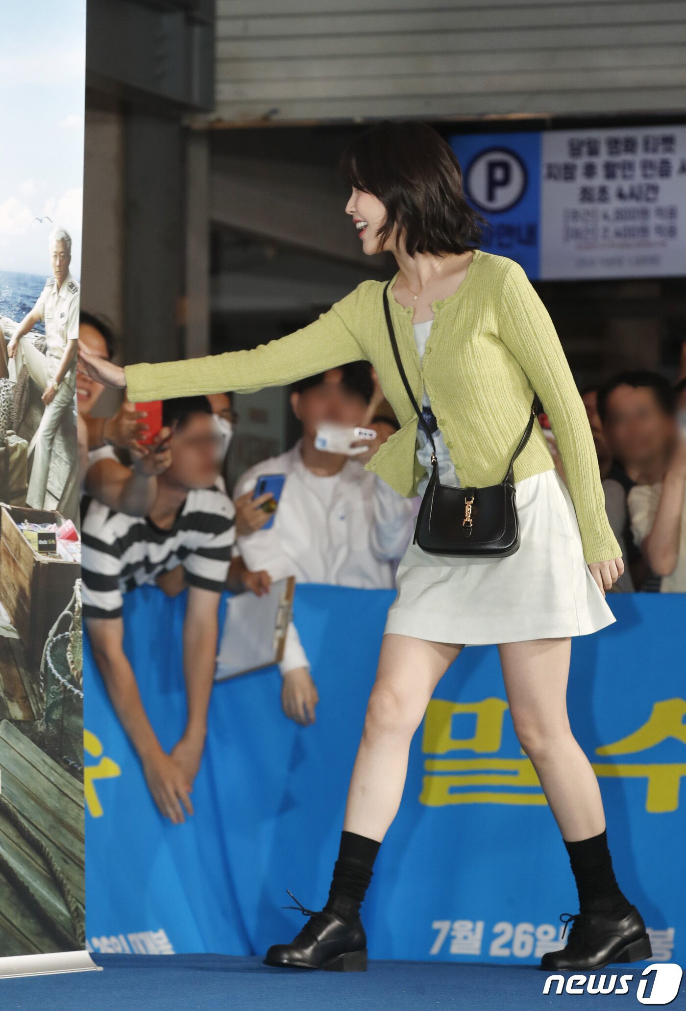 본문 이미지 - 가수 아이유가 20일 서울 강남구 코엑스 메가박스에서 열린 영화 '밀수'(감독 류승완) VIP 시사회에서 환호하는 팬에게 손 인사로 화답하고 있다. ⓒ News1 권현진 기자