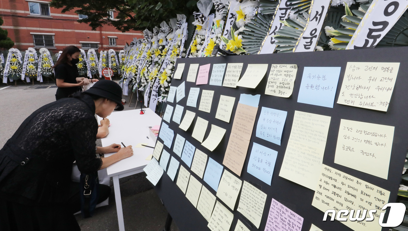 (서울=뉴스1) 박지혜 기자 = 21일 서울 강남구 강남서초교육지원청에 마련된 서이초등학교 교사 분향소를 찾은 추모객들이 추모의 글을 적고 있다. 2023.7.21/뉴스1