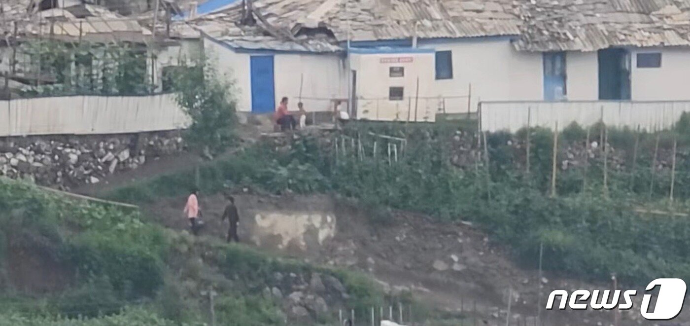 본문 이미지 - 북한 양강도 혜산시에서 주민들이 오전에 한가로운 일상을 보내고 있다. 위쪽에는 아기 두 명과 엄마로 보이는 사람이 함께 놀이를 하고 있는 모습. 2023.7.22/뉴스1 ⓒ News1 최소망 기자