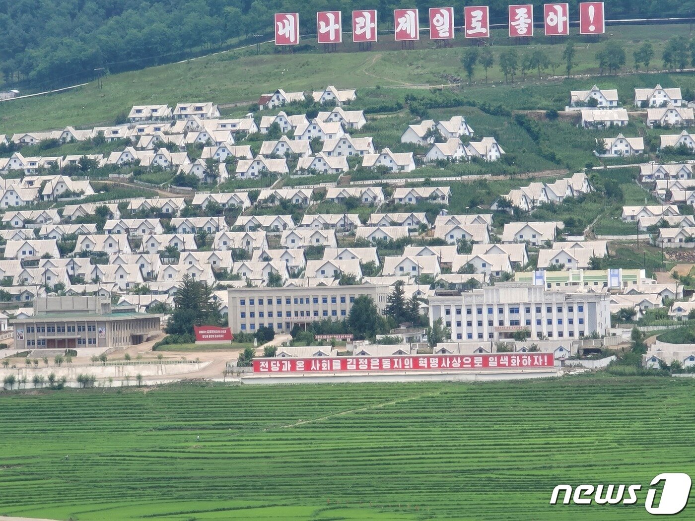 본문 이미지 - 북한 자강도 중강군의 한 마을. 깔끔한 디자인의 집들이 마을을 이루고 있다. 마을 곳곳에는 '내 나라 제일로 좋아', '전당은 온 사회를 김정은 동지의 혁명사상으로 일색화하자' 등의 선전 구호들이 자리하고 있다. 2023.7.22/뉴스1 ⓒ News1 최소망 기자