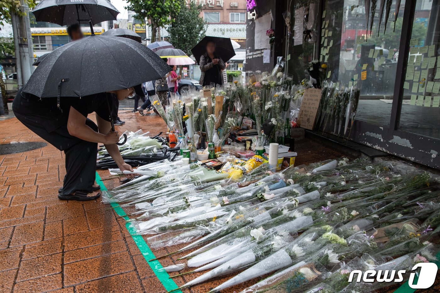 본문 이미지 - 23일 오전 서울 관악구 신림동 '묻지마 흉기 난동' 사건 현장을 찾은 한 시민이 조화를 내려 놓고 있다. 2023.7.23/뉴스1 ⓒ News1 이재명 기자