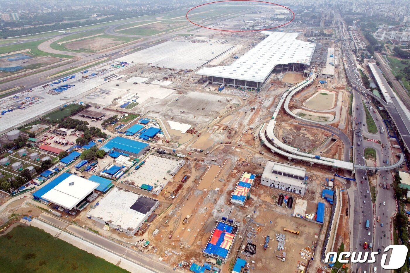 본문 이미지 - 삼성물산이 방글라데시 수도 다카에 증설 중인 하즈랏 샤잘랄 국제공항(HSIA) 공사 현장. 붉은 동그라미 부분과 활주로, 유도로 2개만 기존 시설이고 나머지 건물과 교량 등이 모두 신설 중이다. 2023. 7. 16/뉴스1(삼성물산 제공 현장 드론 촬영 사진) ⓒ News1 최서윤 기자