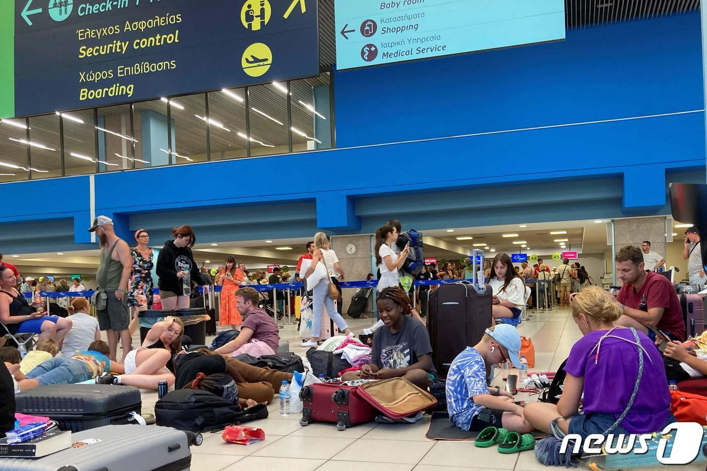 본문 이미지 - 23일(현지시간) 그리스 로도스 공항 출국장에 산불로부터 대피한 관광객들이 여객기를 기다리는 모습이다. 2023.7.23. ⓒ AFP=뉴스1 ⓒ News1 김성식 기자