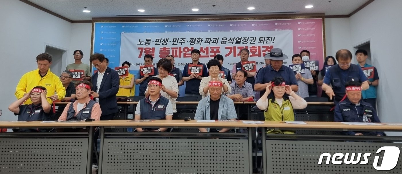 본문 이미지 - 전국민주노동조합총연맹 전북지역본부가 3일 전북 전주시 덕진구 민주노총전북본부 대회의실에서 기자회견을 열고 총파업 투쟁을 선언했다. 전북 시민사회단체 관계자들이 민주노총 관계자들의 머리에 '가자, 총파업'이라고 써있는 붉은색 머리띠를 묶어주고 있는 모습.2023.7.3/뉴스1 이지선기자