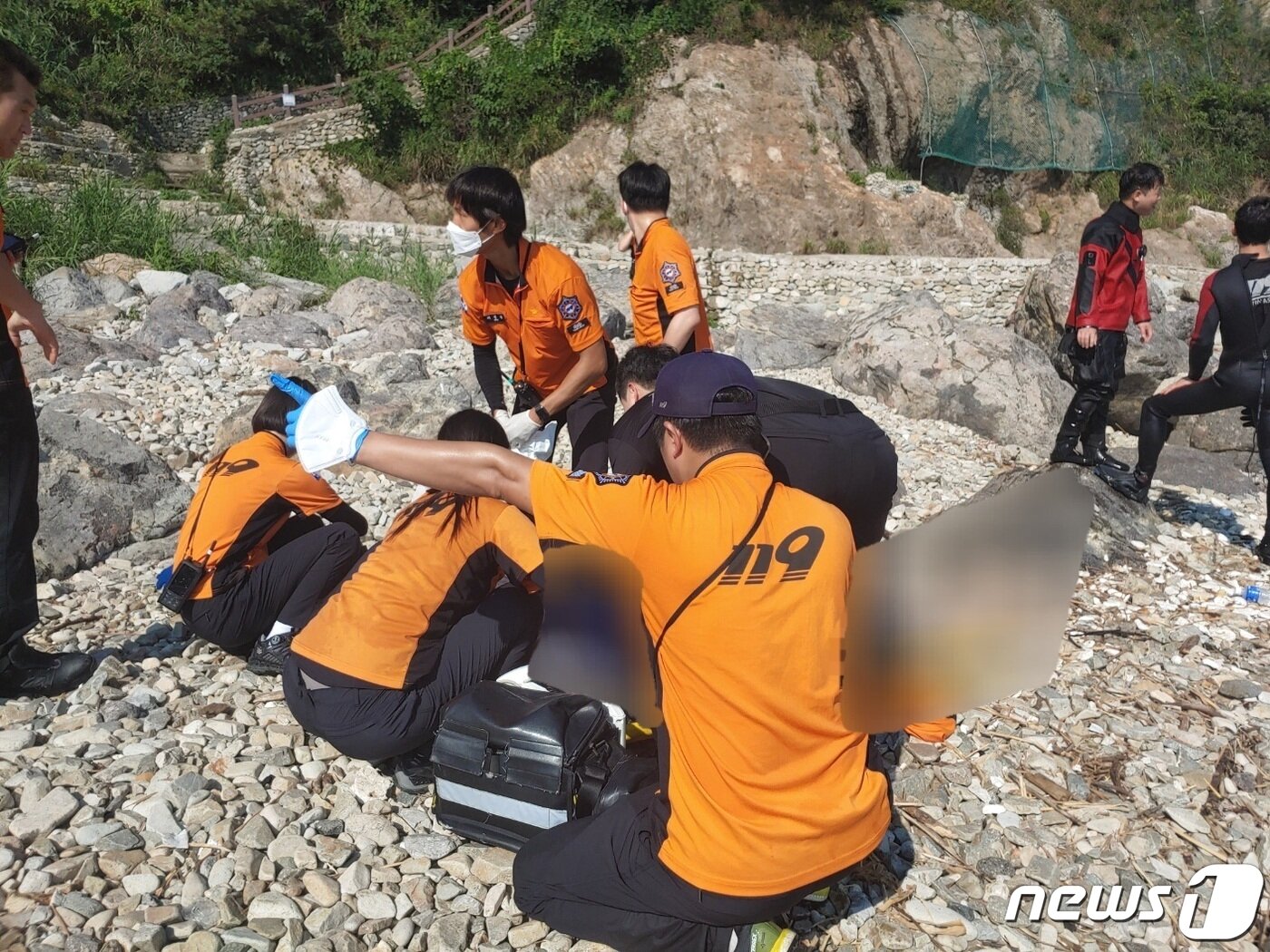 본문 이미지 -  지난 29일 부산 영도구 동삼동 영도하늘전망대 자갈마당 인근 바다에서 A씨가 발견돼 소방대원들이 안전 조치를 하고 있다. (부산소방재난본부 제공)