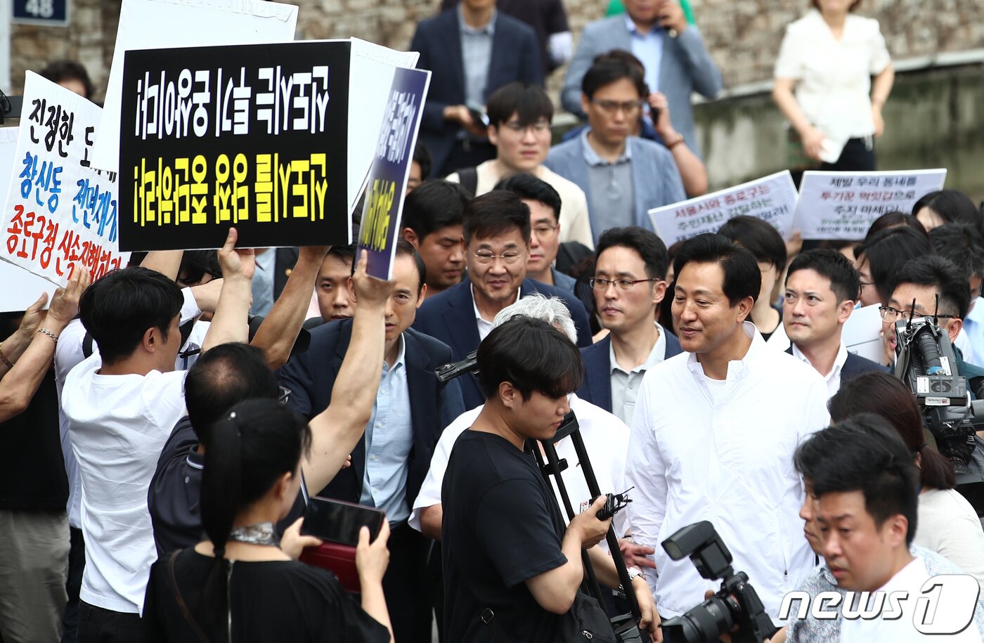 본문 이미지 - 오세훈 서울시장이 5일 서울 종로구 창신동 신속통합기획안 재개발 후보지를 찾아 현장을 둘러보고 있다. 왼편에는 창신동 재개발을 반대하는 주민들과 12구역 재개발 선정을 촉구하는 주민들이 손피켓을 들고 있다. 2023.7.5/뉴스1 ⓒ News1 김민지 기자