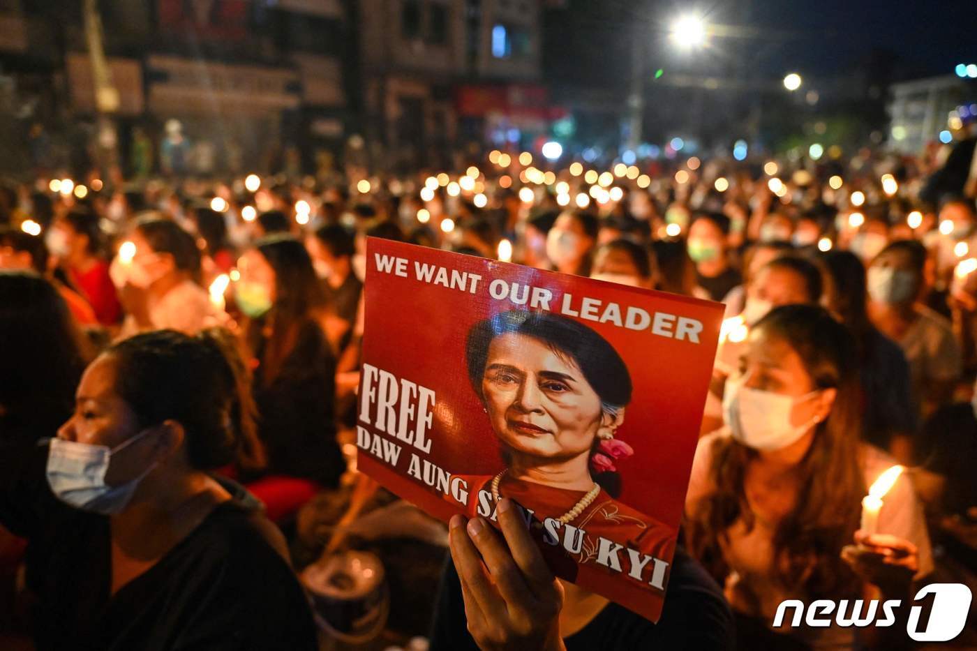 본문 이미지 - 지난 2021년 3월 13일(현지시간) 미얀마 양곤에서 군부 쿠데타에 반대하는 시위 중 사망한 사람들을 기리기 위해 한 시위자가 아웅산 수치의 이미지가 담긴 포스터를 들고 있다. 아웅산 수치는 지난 2021년 군부 쿠데타로 축출된 이후 현재 가택연금 상태에 있다. 2023.08.01/ ⓒ AFP=뉴스1 ⓒ News1 임윤지 기자