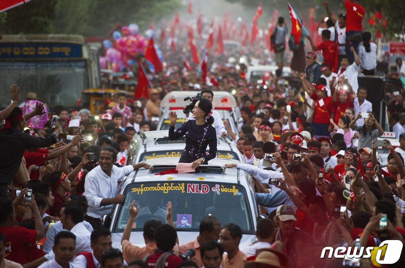 본문 이미지 - 지난 2015년 11월 1일(현지시간) 미얀마 양곤에서 아웅산 수치 전 국가고문이 차량 행렬을 따라 이동하며 지지자들에게 손짓하고 있다. 2023.08.01/ ⓒ AFP=뉴스1 ⓒ News1 임윤지 기자