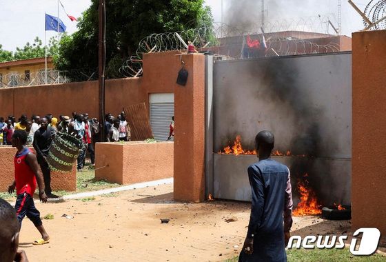 30일(현지시간) 서아프리카 니제르의 수도 니아메에서 니제르 쿠데타를 주도한 군부 세력의 지지자들이 프랑스 대사관 밖에서 시위하며 정문에 불을 지르고 있다. 2023.07.30/ © 로이터=뉴스1 © News1 박재하 기자