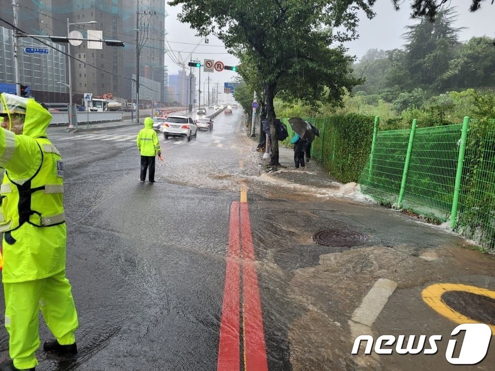 본문 이미지 - 10일 오전 8시15분께 부산 동래구 해양자연사박물관 앞에 물이 흘러내리고 있어 1개 차선이 통제되고 있다. (부산경찰청 제공)