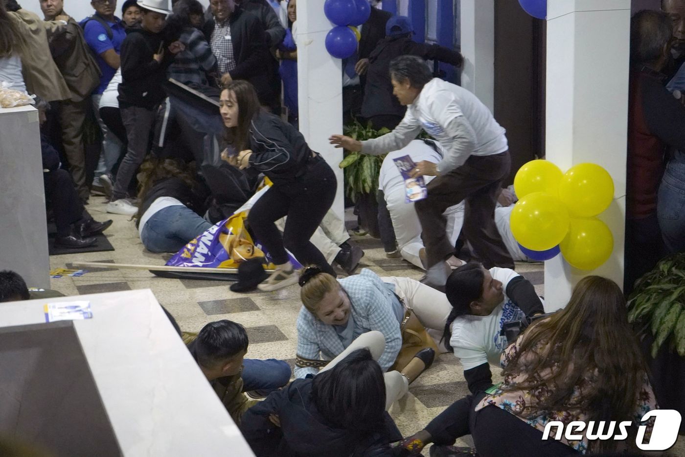 본문 이미지 - 9일(현지시간) 에콰도르 키토에서 열린 대선 후보 페르난도 비야비센시오의 집회에서 총이 발사된 후 장내의 사람들이 몸을 피하고 있다. 현지 언론은 내무장관을 인용, 총격으로 페르난도 비야비센시오 후보가 사망했다고 보도했다. 2023.08.10/ ⓒ AFP=뉴스1 ⓒ News1 김형준 기자