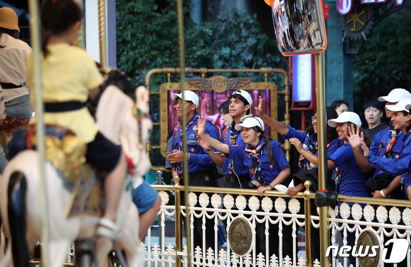 본문 이미지 - 2023 세계스카우트잼버리에 참가한 멕시코 스카우트 대원들이 10일 오전 서울 송파구 롯데월드어드벤처에서 놀이기구를 타기 위해 대기하며 시민들에게 인사하고 있다. 2023.8.10/뉴스1 ⓒ News1 구윤성 기자