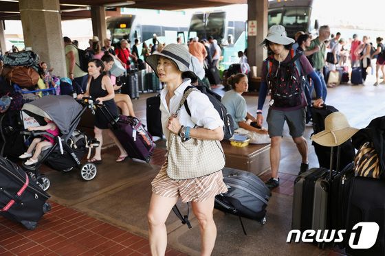 10일(현지시간) 미국 하와이 마우이에서 산불로부터 대피한 이재민들이 짐을 챙겨 카훌루이 공항으로 들어서고 있다. 2023.08.11/ © 로이터=뉴스1 © News1 김형준 기자