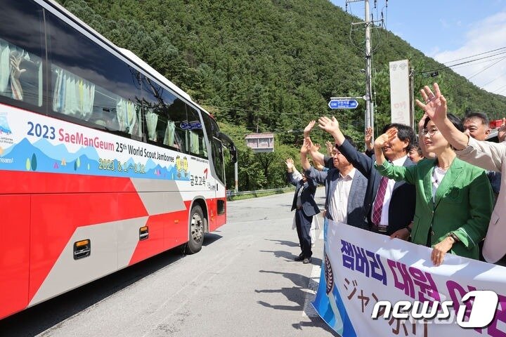 본문 이미지 - 2023세계스카우트 잼버리 일본 대원들을 태운 버스가 11일 단양군 공무원과 구인사 관계자 등의 환송을 받으며 단양 구인사를 떠나고 있다. (단양군 제공) /뉴스1