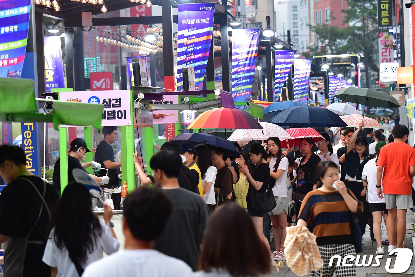 12일 오후 경북 포항시 중앙상가 실개천에서 열린 &#39;2023포항중앙상가 야시장&#39;에서 시민과 관광객들이 갑자기 내린 가을비에 우산을 들고 음식을 기다리고 있다.2023.8.12/뉴스1 ⓒ News1 최창호 기자