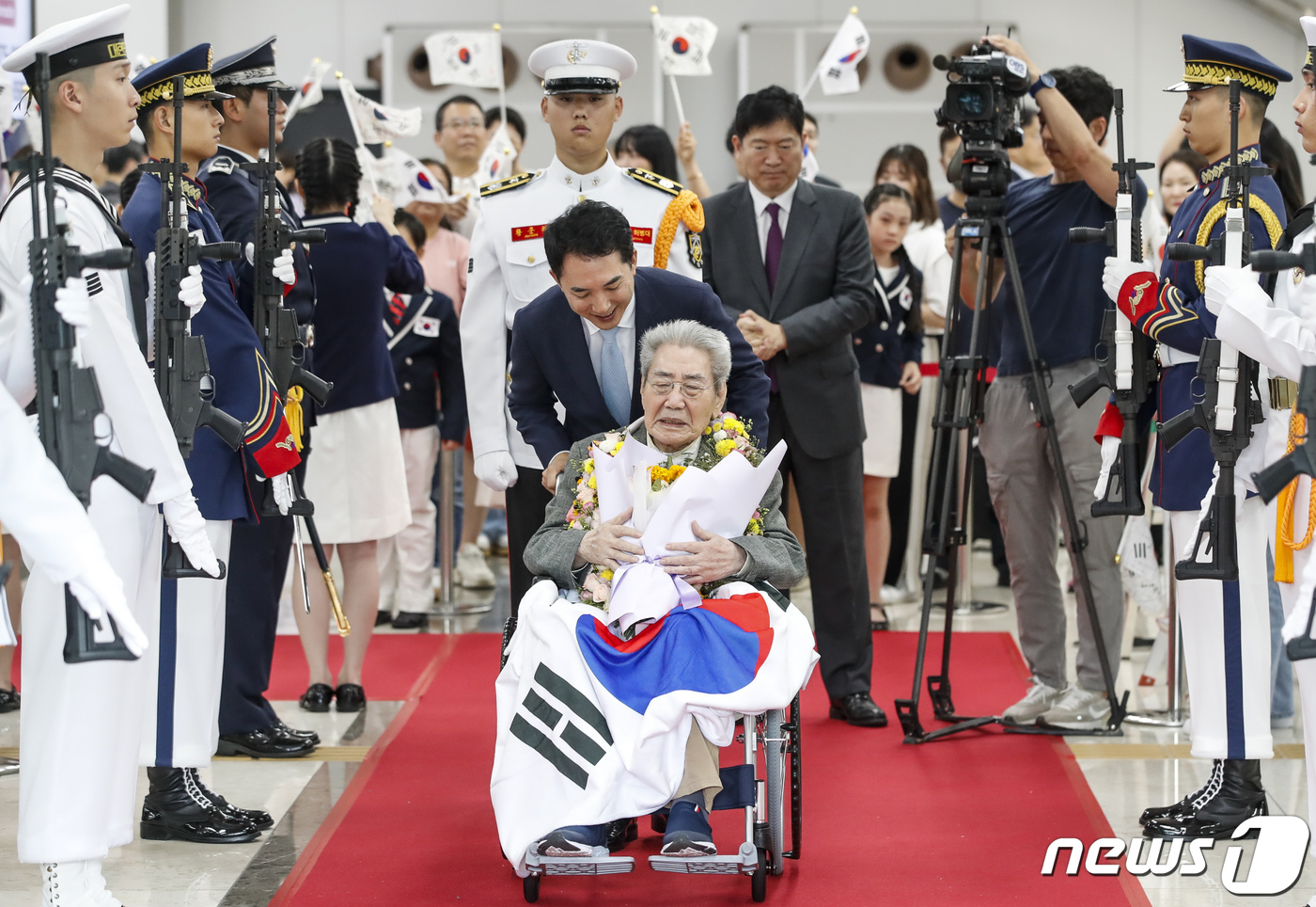 (서울=뉴스1) 김도우 기자 = 마지막 재일독립유공자 오성규 애국지사가 13일 서울 강서구 김포공항에서 열린 환국 환영 행사를 마치고 박민식 보훈부장관과 길을 나서고 있다.오 지사 …