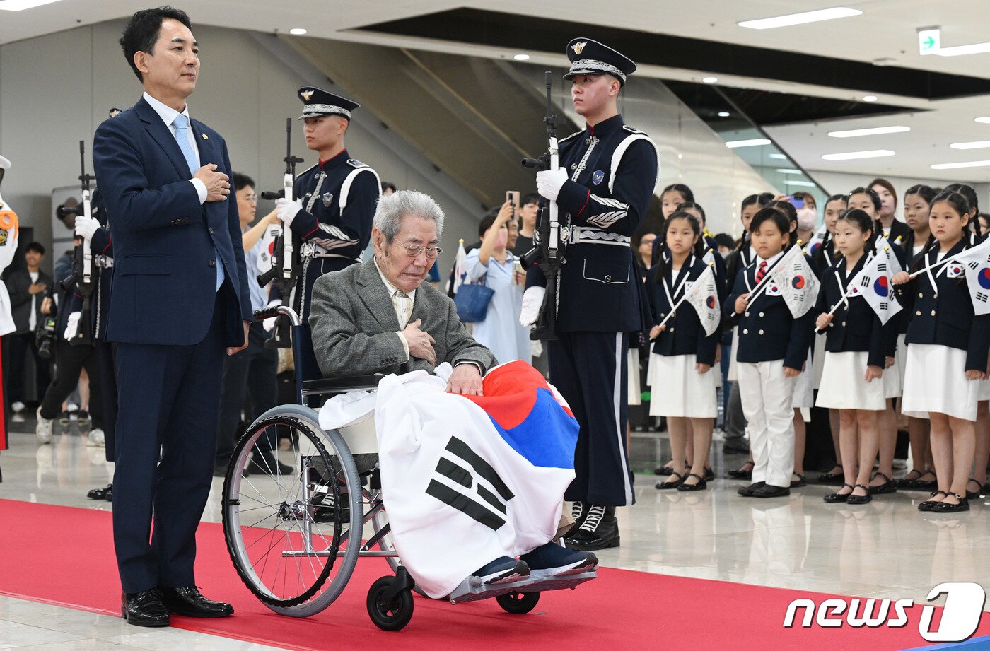 본문 이미지 - 마지막 재일독립유공자 오성규 애국지사가 13일 서울 강서구 김포공항에서 열린 환국 환영행사에서 박민식 국가보훈부 장관과 국민의례를 하고 있다. 오 지사는 일제강점기 중국 만주 봉천 소재 동광중학을 중심으로 항일운동을 했고, 일제에 조직망이 노출되자 만주를 탈출해 중국 안후이성의 한국광복군 제3지대에 입대해 독립운동을 펼쳤다. (공동취재) 2023.8.13/뉴스1 ⓒ News1 김도우 기자