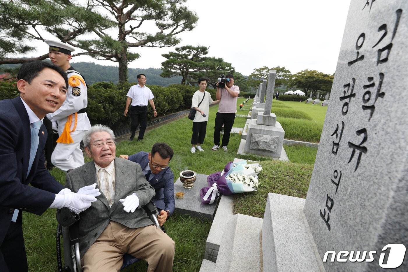 본문 이미지 - 유일한 생존 독립유공자인 광복군 출신 오성규 애국지사가 13일 서울 동작구 국립서울현충원에서 광복군 제3지대장 김학규 장군 묘역에 환국 신고와 참배를 마치고 묘비를 바라보고 있다. 왼쪽은 박민식 국가보훈부 장관. 2023.8.13/뉴스1 ⓒ News1 김민지 기자