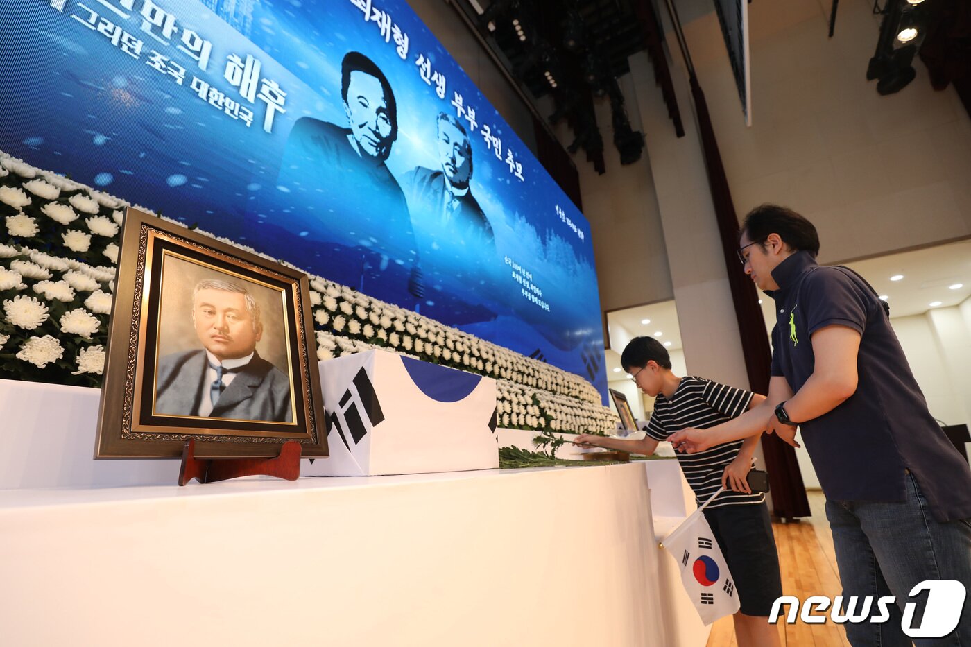 본문 이미지 - 13일 서울 동작구 국립서울현충원 현충관에 마련된 독립운동가 고(故) 최재형 선생과 부인 최 엘레나 페트로브나 여사 부부에 대한 국민추모공간을 찾은 한 가족이 헌화하고 있다. 103년 만에 고국의 품으로 돌아온 최 선생 부부의 현충원 합장식은 제78주년 광복절을 하루 앞둔 오는 14일 진행된다. 2023.8.13/뉴스1전 ⓒ News1 김민지 기자