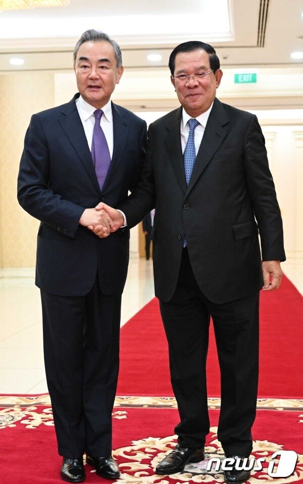 본문 이미지 - 왕이 중국 외교부장과 훈센 캄보디아 총리가 13일 캄보디아 프놈펜에서 만나 악수를 나누고 있다. <출처=중국 외교부>