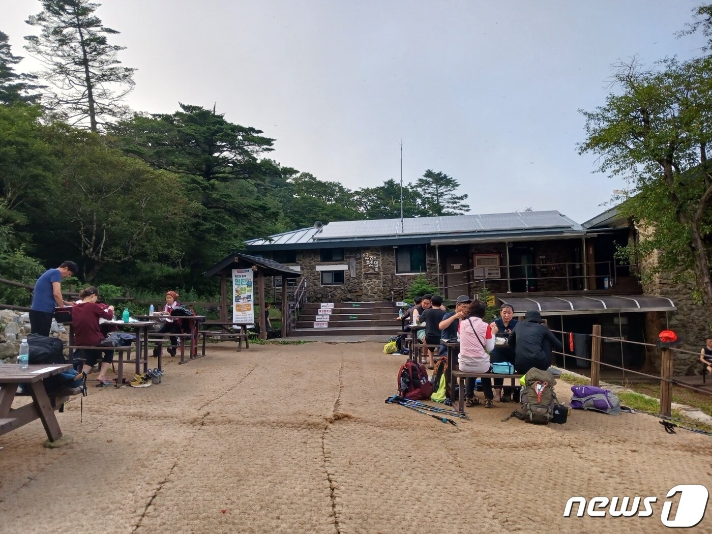 본문 이미지 - 이름도 예쁘고 모습도 아담한 연하천 대피소는 능선 아래에 위치해 아늑하기까지 하다. 마실 수 있는 물도 가까이 있어 지친 탐방객들을 달래준다. 삼삼오오 모여  준비해온 음식을 먹는 대피소 저녁 풍경. ⓒ 뉴스1