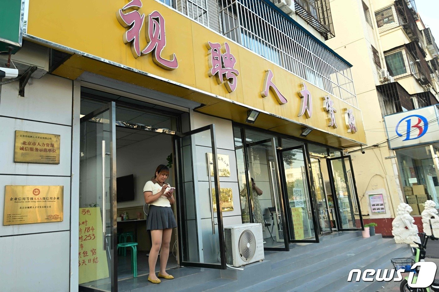 본문 이미지 - 지난 6월 청년실업률이 21.3%를 기록한 중국이 8월부터는 전국 청년 및 기타 연령대의 실업률 조사를 중단하기로 했다. 사진은 한 여성이 베이징의 한 구직 사무실 입구에 서 있는 모습.2023.08.15. ⓒ AFP=뉴스1 ⓒ News1 권영미 기자