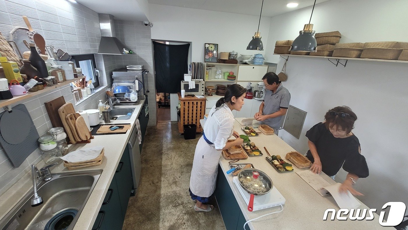 본문 이미지 -  서귀포시 남원읍 한 식당에서  관광객들이 &#39;차롱도시락&#39; 만드는 법을 배우고 있다.