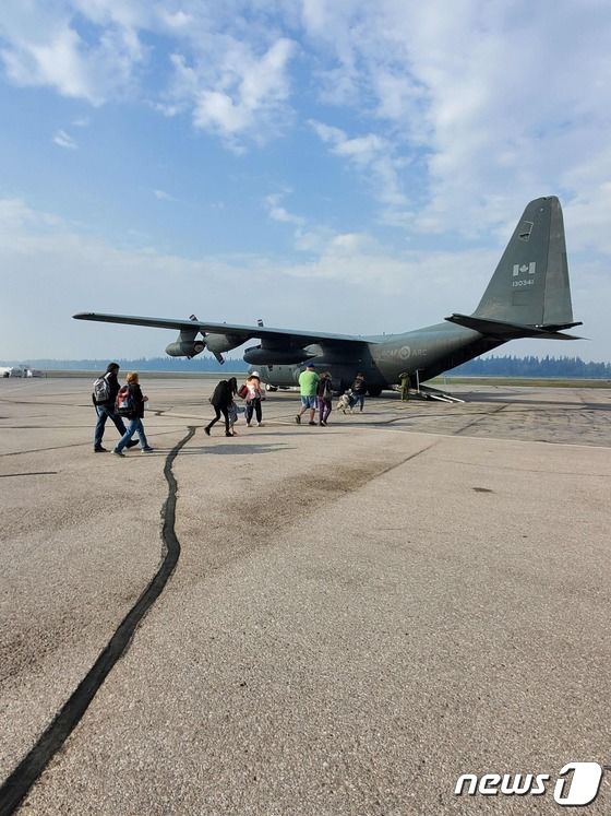14일(현지시간) 캐나다 포트 스미스 지역 주민들이 군용기를 타고 산불을 피해 대피하고 있다. 2023.08.14/ © AFP=뉴스1 © News1 권진영 기자