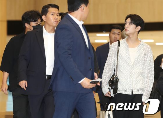 세븐틴 조슈아가 해외 일정을 위해 17일 오후 김포국제공항에 도착해 출국장으로 이동하며 환호하는 팬을 바라보고 있다.  © News1 권현진 기자