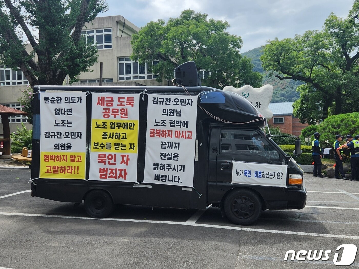 본문 이미지 - 18일 의령군청 앞에서 공무원을 비방하는 내용을 담은  펼침막을 부착하고 확성기로 방송하고 있는 차량. /뉴스1 박종완 기자