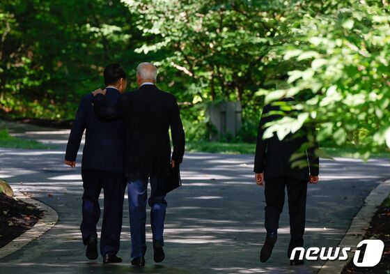 윤석열 대통령(왼쪽)과 조 바이든 미국 대통령(가운데), 기시다 후미오 일본 총리가 18일(현지시간) 오후 미국 워싱턴DC 인근 대통령 별장인 '캠프 데이비드'에서 한미일 정상회의 결과 관련 공동기자회견을 진행한 뒤 돌아가고 있다. © 로이터=뉴스1 © News1 정지형 기자
