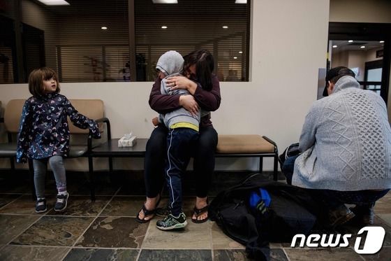 18일(현지시간) 산불로 대피령이 내려진 캐나다 옐로나이프에서 항공기를 타고 앨버타주에 도착한 한 이재민 가족이 서로를 껴안고 울고 있다. 2023.08.18/ © AFP=뉴스1 © News1 권진영 기자